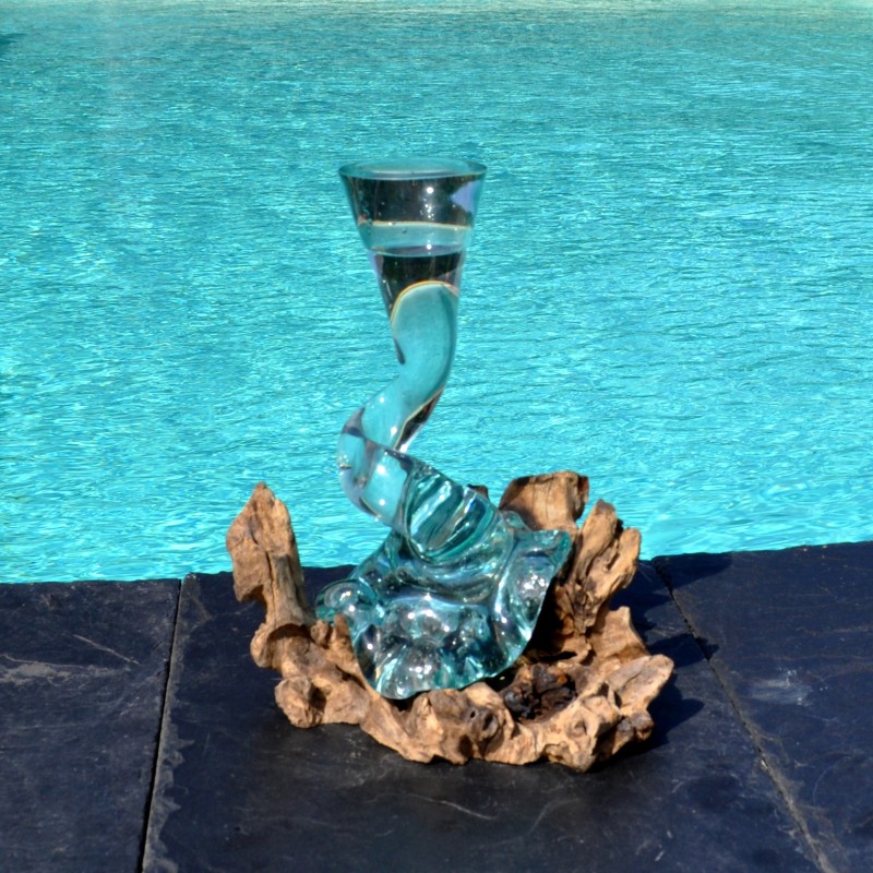 Un soliflore tortueux en verre soufflé et moulé sur du bois flotté