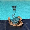 Un soliflore tortueux en verre soufflé et moulé sur du bois flotté