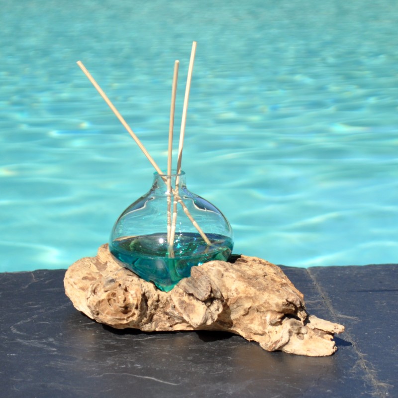 Un diffuseur de parfum en verre recyclé soufflé en fusion sur du bois flotté