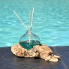 Un diffuseur de parfum en verre recyclé soufflé en fusion sur du bois flotté