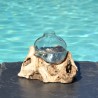 Un diffuseur de parfum en verre recyclé soufflé à la bouche en fusion sur du bois flotté