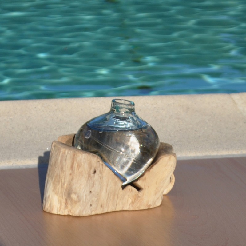 Un diffuseur de parfum en verre recyclé soufflé en fusion sur du bois flotté