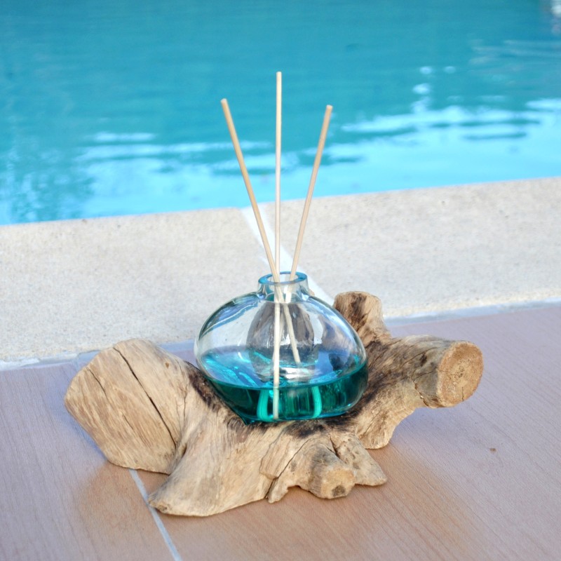 Un diffuseur de parfum en verre recyclé soufflé en fusion sur du bois flotté