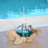 Un diffuseur de parfum en verre recyclé soufflé en fusion sur du bois flotté