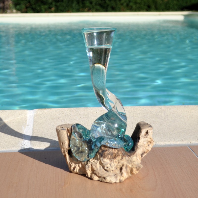 Un soliflore tortueux en verre soufflé et moulé sur du bois flotté