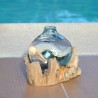 Un diffuseur de parfum en verre recyclé soufflé en fusion sur du bois flotté