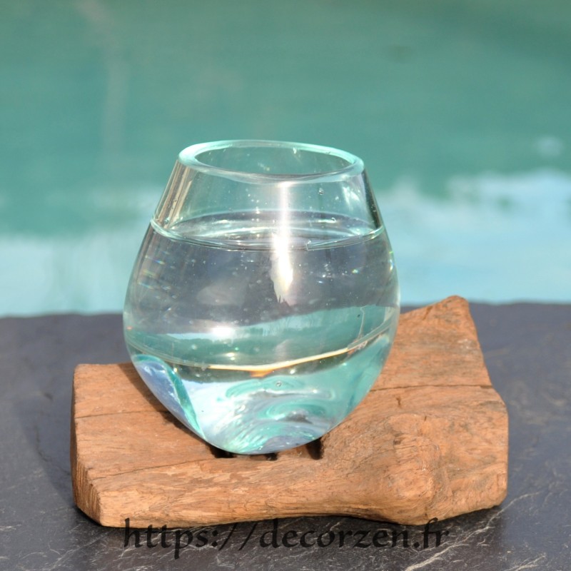 Un merveilleux verre en verre recyclé soufflé sur une racine.