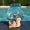Un verre recyclé soufflé et moulé en fusion sur du bois flotté de teck
