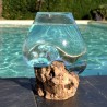 Un verre recyclé soufflé et moulé en fusion sur du bois flotté de teck
