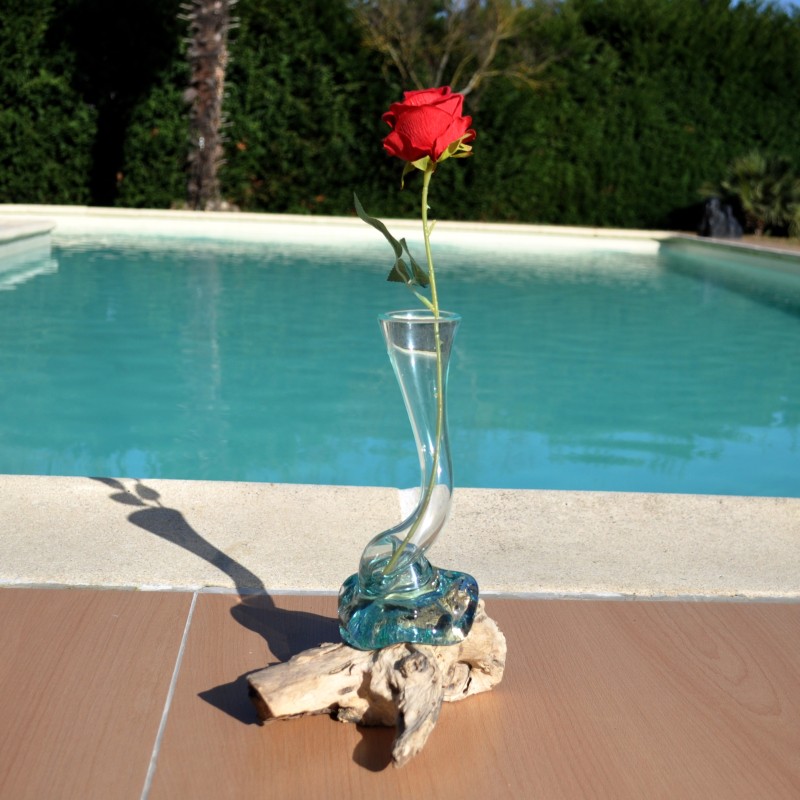 Un soliflore tortueux en verre soufflé et moulé sur du bois flotté