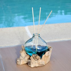 Un diffuseur de parfum en verre recyclé soufflé en fusion sur du bois flotté