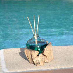 Un diffuseur de parfum en verre recyclé soufflé en fusion sur du bois flotté