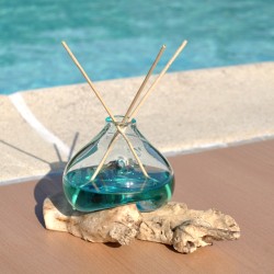 Un diffuseur de parfum en verre recyclé soufflé en fusion sur du bois flotté