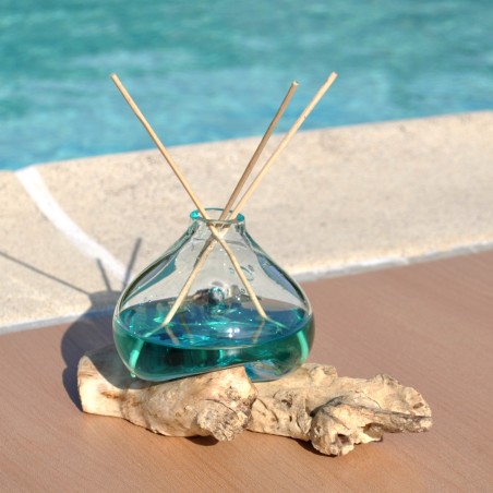 Un diffuseur de parfum en verre recyclé soufflé en fusion sur du bois flotté