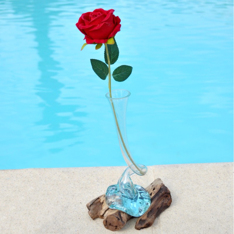 Un soliflore tortueux en verre soufflé et moulé sur du bois flotté