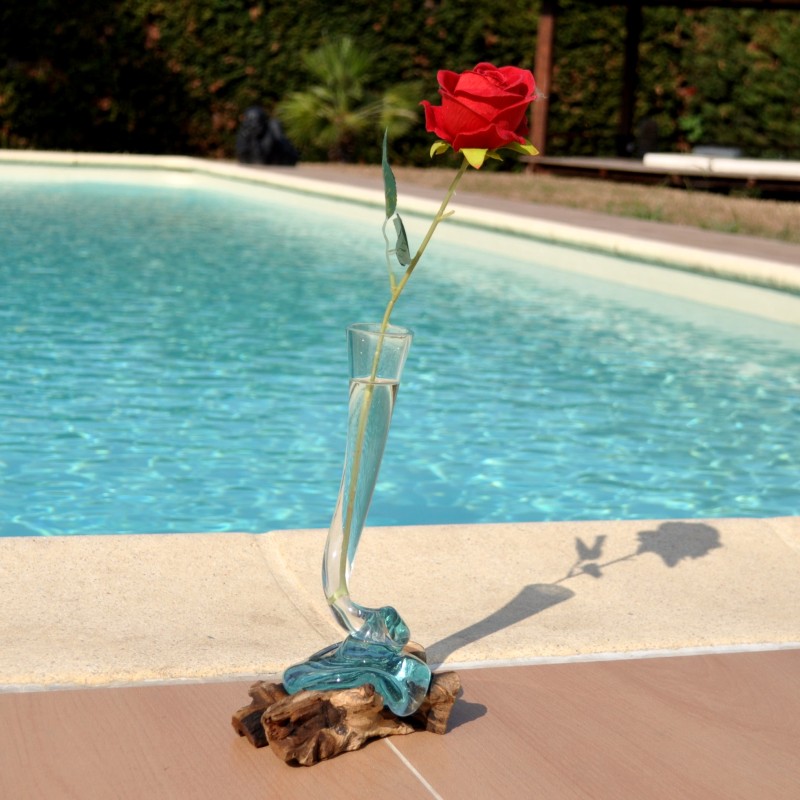 Un soliflore tortueux en verre soufflé et moulé sur du bois flotté
