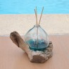 Un diffuseur de parfum en verre recyclé soufflé en fusion sur du bois flotté