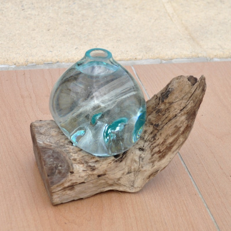 Un diffuseur de parfum en verre recyclé soufflé en fusion sur du bois flotté